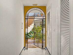 A hallway with a decorative metal gate leading to a staircase.