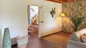 A living room with a sofa, a large vase, a lamp, and a staircase leading to another room. - Holiday home on Lake Ternscher with private jetty (Selm)