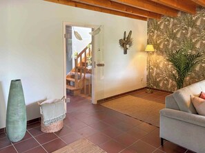 A living room with a sofa, a large vase, a lamp, and a staircase leading to another room. - Holiday home on Lake Ternscher with private jetty (Selm)