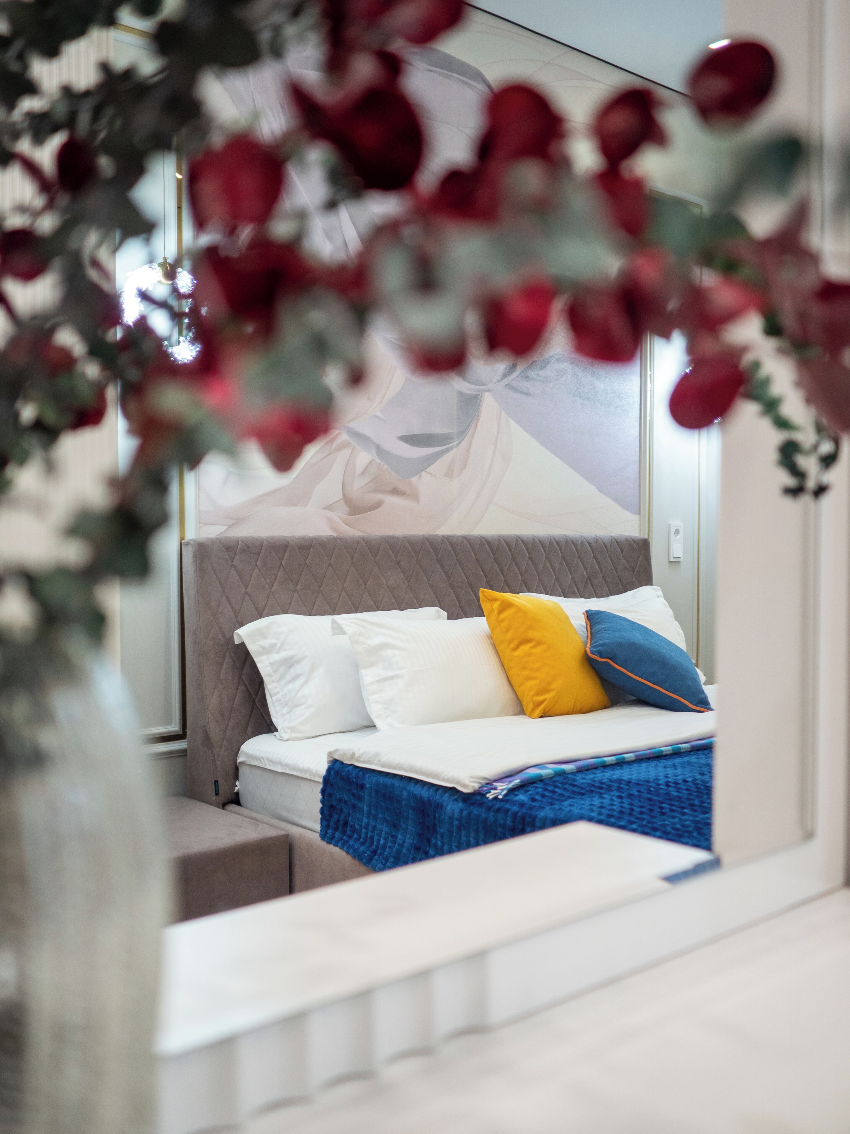 Un dormitorio con cama, almohadas y una colcha azul.
