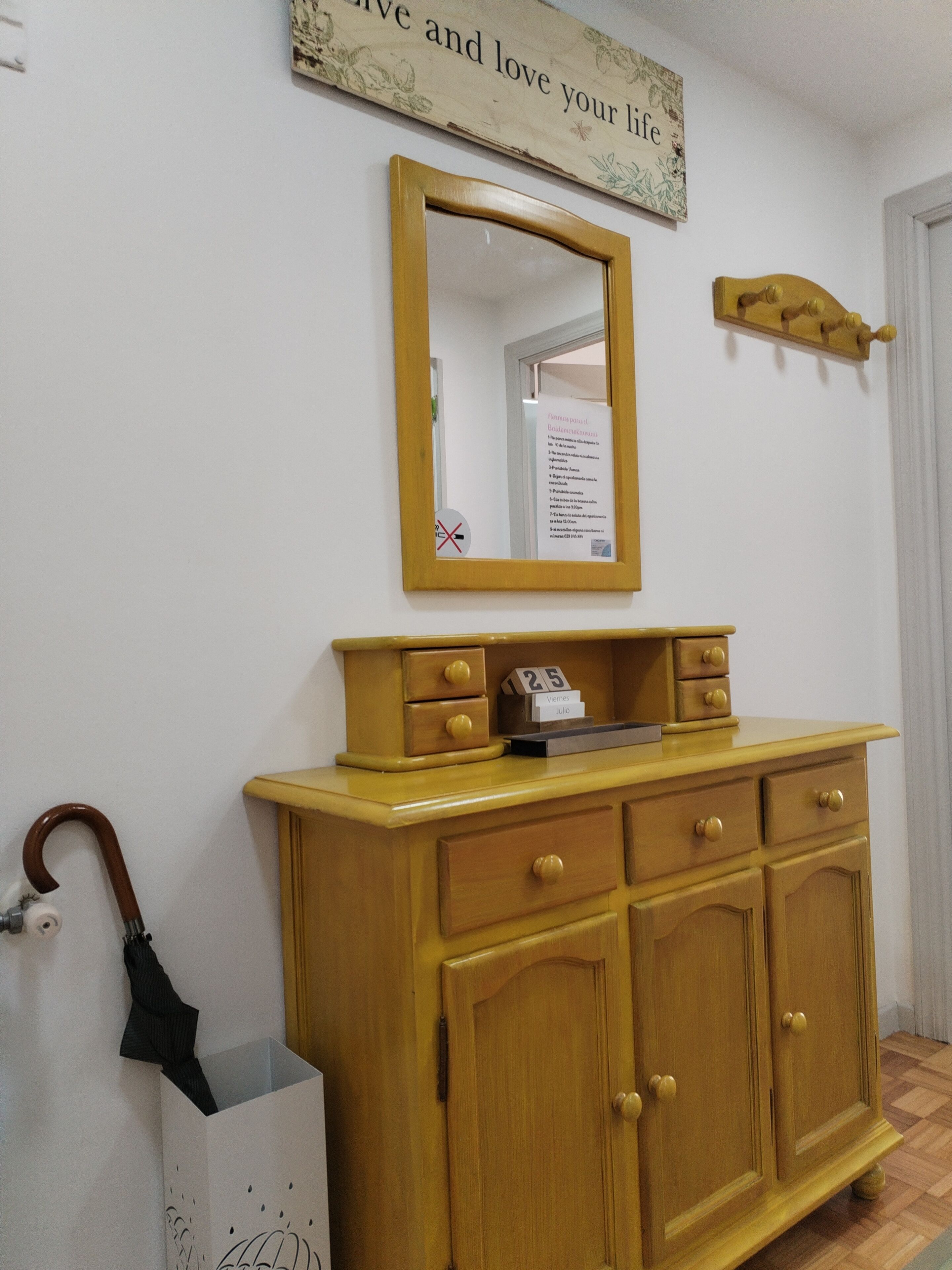 Een houten kast met lades en een spiegel erboven.