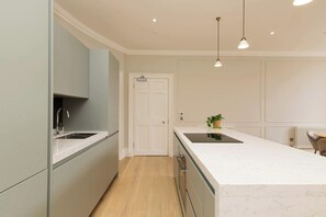 Een moderne keuken met een centraal eiland, een ingebouwde oven en een spoelbak.