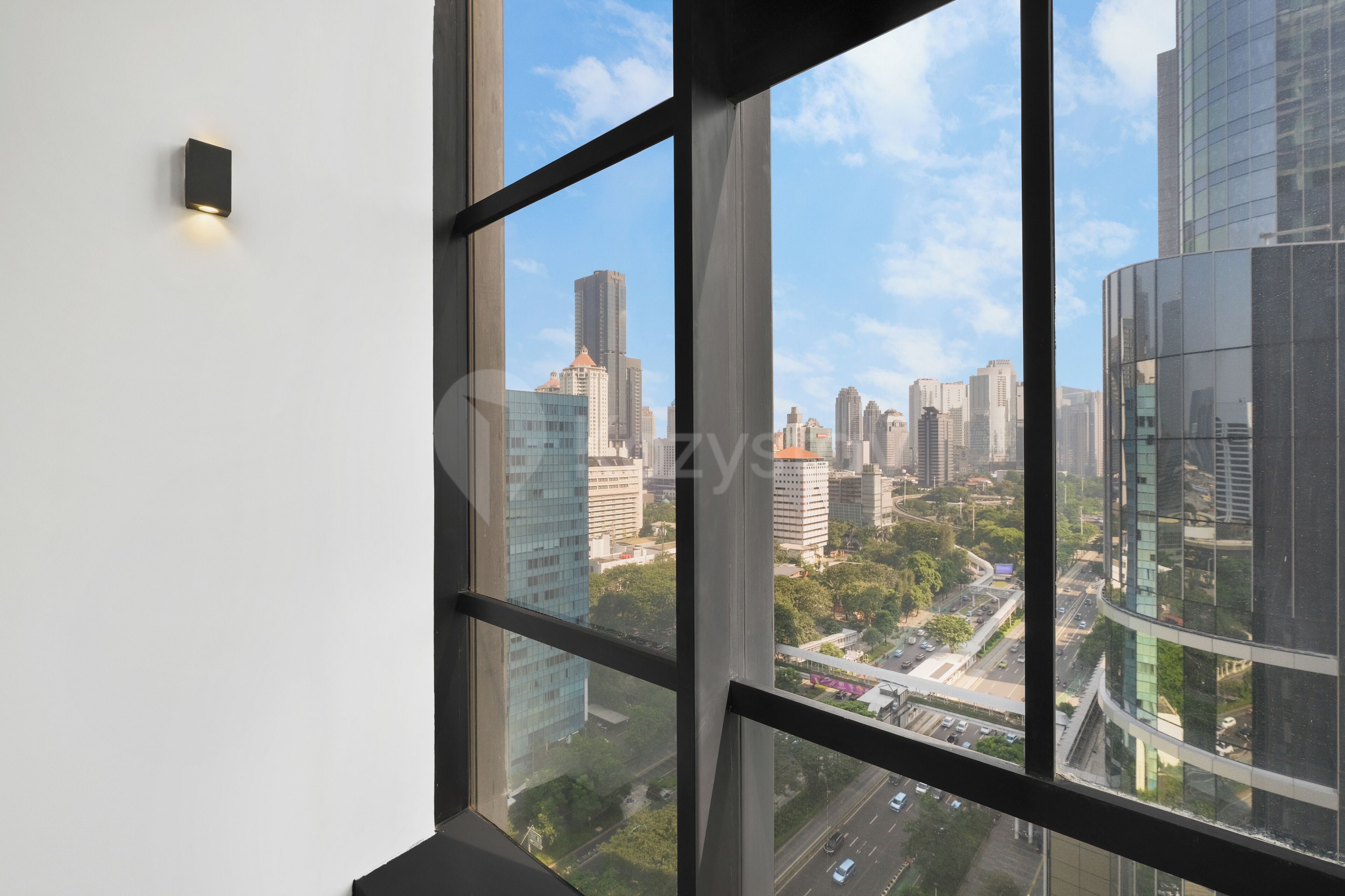 Vista desde una ventana que muestra un paisaje urbano, con edificios altos y una autopista.