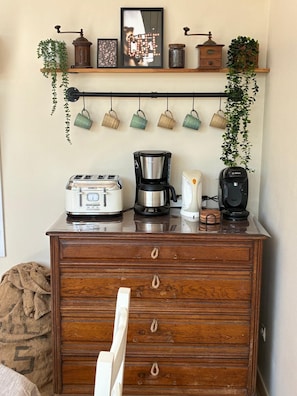 Eine Küchenzeile mit Kaffeemaschine, Toaster und Wasserkocher auf einem Holzkorpus.