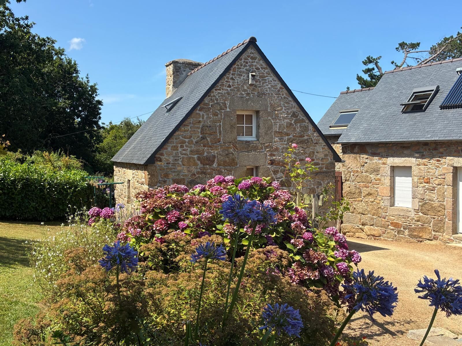 A stone building with a gabled roof, a small window, and a door.