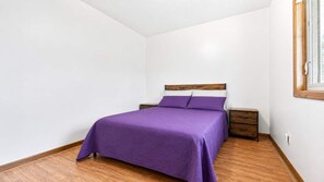 A bedroom with a bed, wooden nightstands, and a window. - Spacious 7BR Brooklyn Center Home for 14 (Minneapolis)