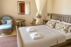 Ein Hotelzimmer mit einem Bett, einem Sessel, einem kleinen Tisch und einem Spiegel.