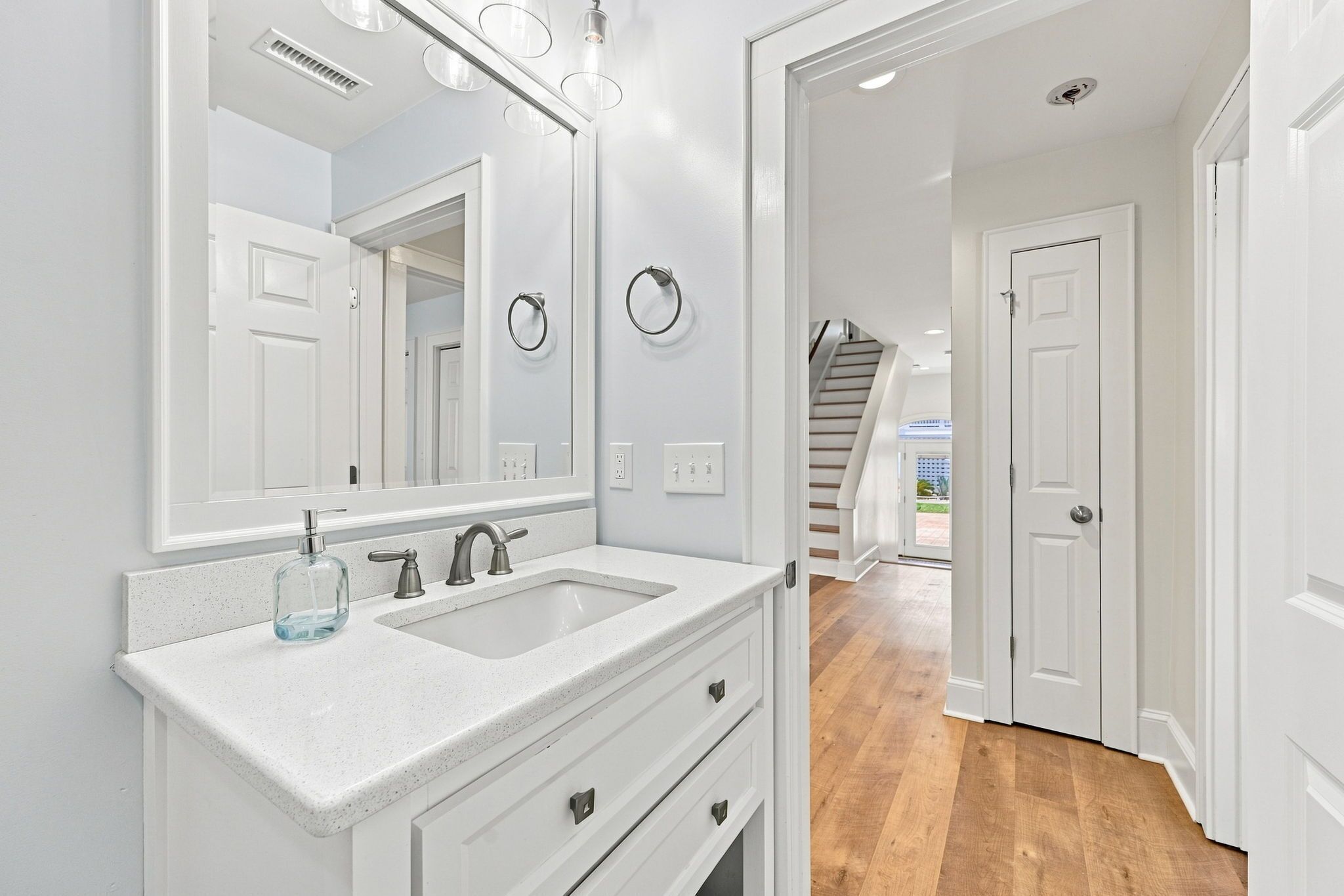 A modern bathroom with a double sink, a large mirror, and a towel ring.