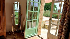 A room with a green door leading to an outdoor area, a mirror, and a wooden cabinet. - Charming bed and breakfast with swimming pool in Dordogne (Plazac)