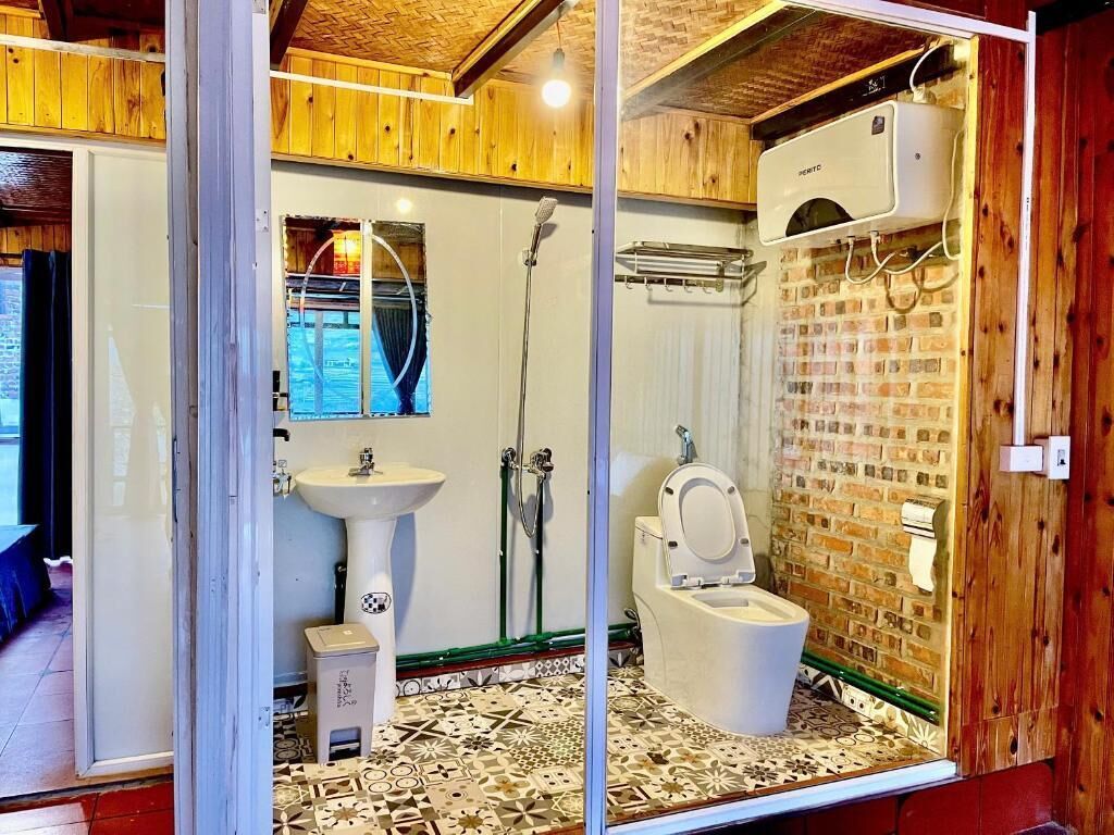 Une salle de bain avec des toilettes, un lavabo et une douche.