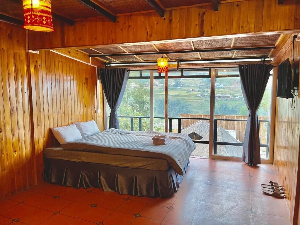 A wooden room with a bed, a window, and a view of the outdoors.