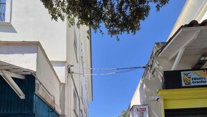 A narrow street with buildings on either side, a closed shutter on the right, and a sign for 'FRUIT & Granite' on the left. - Apple Cake House - Sweet Silvana (Ischia)