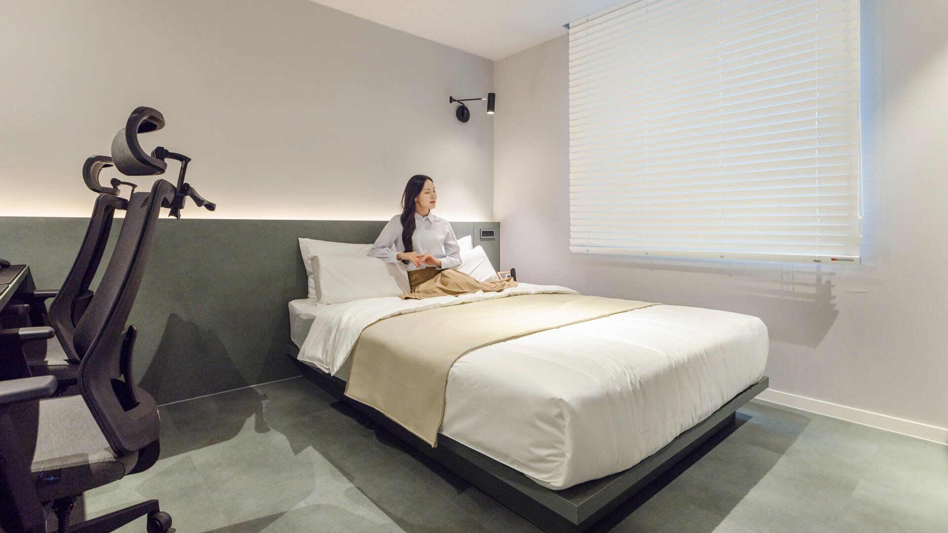 A hotel room with a bed, a desk, and a chair.
