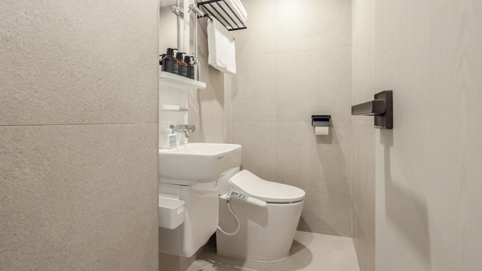 Un bagno moderno con il water, un lavandino e una doccia.