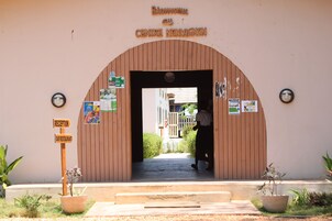 A wooden entrance with a sign reading 'Centre Nonvignon' above it. There are signs for 'Reception' and 'Bar Restaurant' on either side of the entrance.