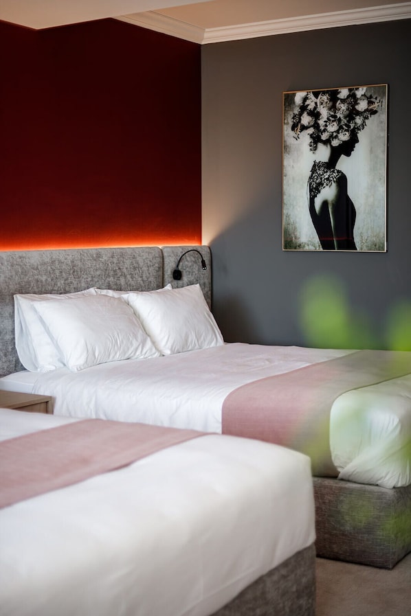 A hotel room with a bed, a bedside table, and a wall-mounted artwork.