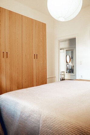 Ein Schlafzimmer mit einem großen Bett, einem Holzschrank und einer Tür zum Badezimmer.