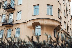 Ein mehrstöckiges Gebäude mit Balkonen und Rundbogenfenstern.