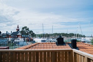 A view of a marina with boats, a red-roofed building, and a clear sky.