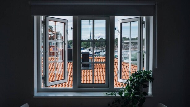 Huone, jossa on suuri ikkuna, josta avautuu näkymä laatoitetulle katolle.