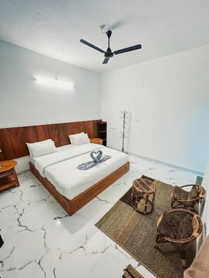 A bedroom with a bed, a ceiling fan, a nightstand, a chair, and a coat rack.
