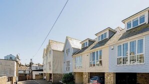 A row of townhouses with a narrow street, a parked car, and a clear sky. - Viking Bay House with Parking and Mins to Viking Bay Beach & Broadstairs Town (Broadstairs)