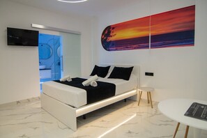 A modern bedroom with a bed, a bedside table, a wall-mounted TV, and a large abstract painting. - AP Alsa 2.1 with Shared Terrace, WiFi and Air Conditioning (Conil de la Frontera)