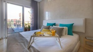 Ein Hotelzimmer mit Bett, Frühstückswagen und Blick ins Freie.