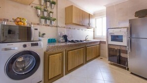 Eine moderne Küche mit Waschmaschine, Mikrowelle, Herd und Kühlschrank.