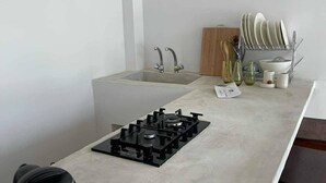 Eine Küche mit Gasherd, Spüle und Geschirrgestell.
