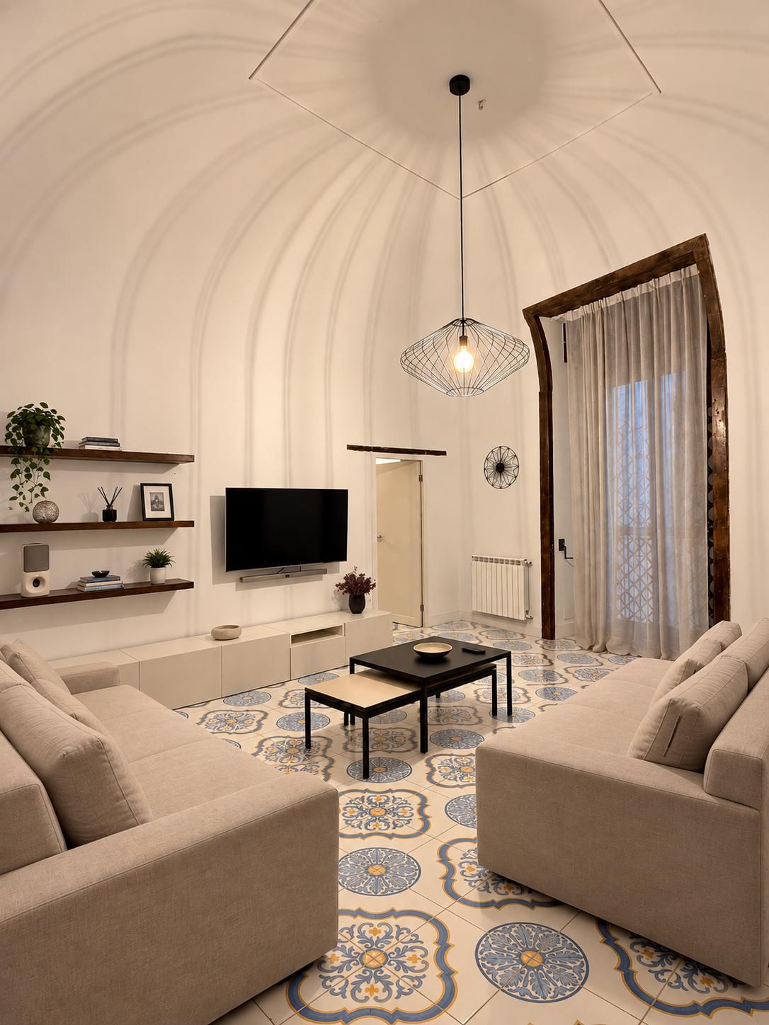 A modern living room with a flat-screen TV, a coffee table, two sofas, and a patterned floor.