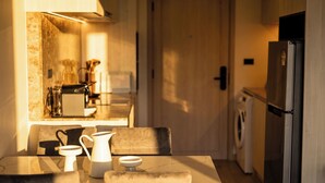 A kitchen with a dining table, chairs, a coffee maker, and a refrigerator. - Bangtao Laguna Apartment 42 sq.m (Thalang District)