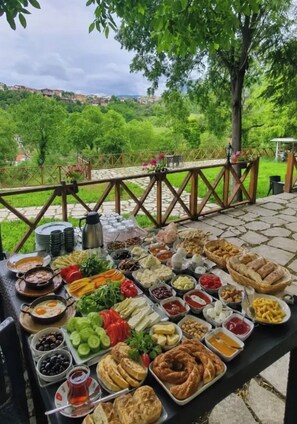 Un espacio para comer al aire libre con diversas opciones de comida y vistas panorámicas de un paisaje verde.