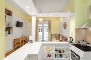 A modern kitchen with a built-in oven, a coffee machine, and a refrigerator with a fruit drawer. - Athens HOME 2 (Athina)
