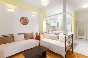 A modern living room with a sofa, a coffee table, and a decorative clock on the wall. - Athens HOME 2 (Athina)