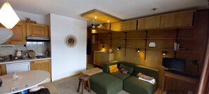 A compact living space with a kitchenette, a dining area, and a seating area with a sofa and a TV. - Studio with a stunning view of Notre-Dame-de-Bellecombe, the Alps, Mont Blanc, the Aravis, and the Beaufortain (Notre-Dame-de-Bellecombe)