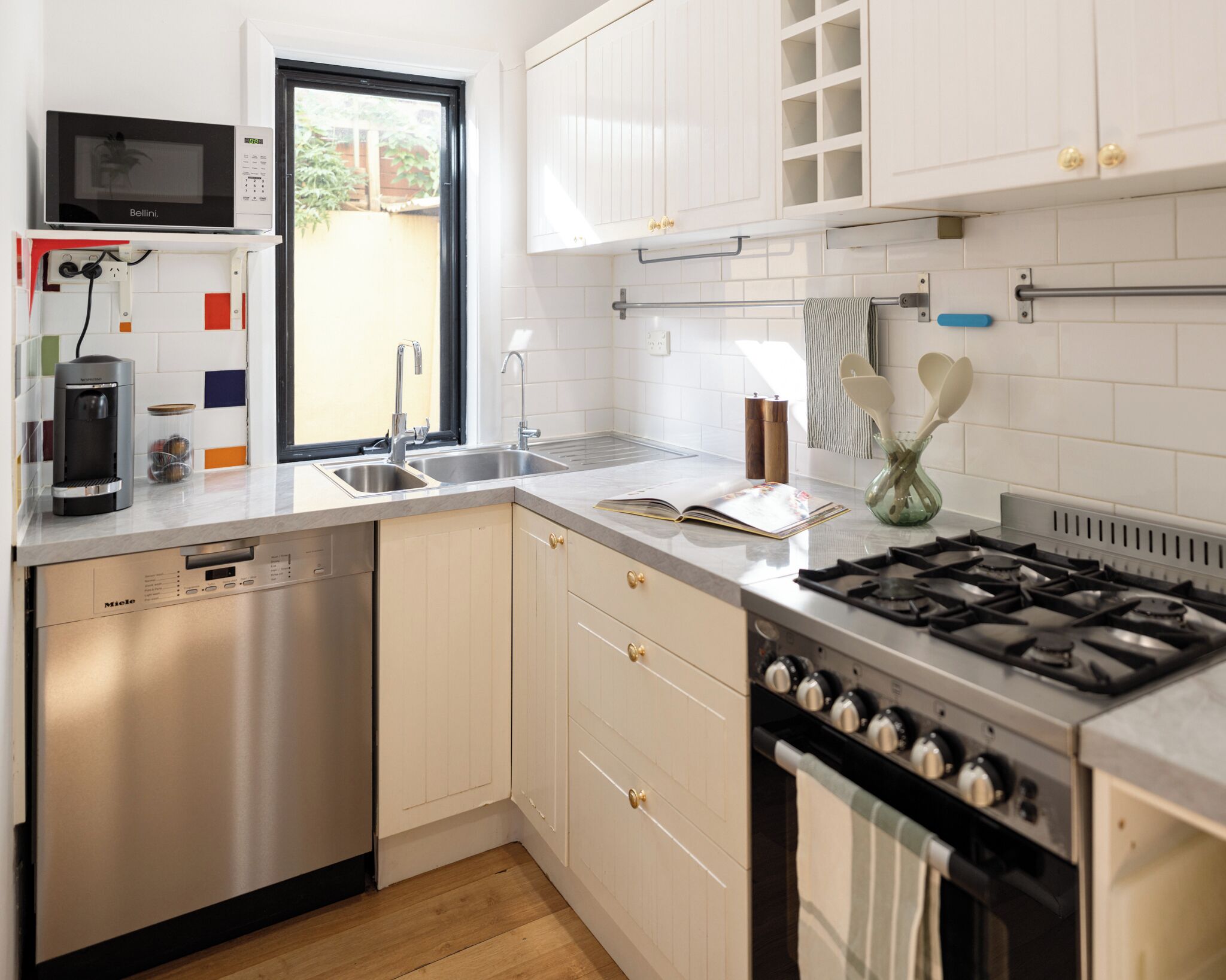 A modern kitchen with a Bosch dishwasher, a built-in stove, and a window providing natural light.