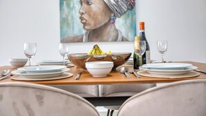 A dining table set with plates, bowls, wine glasses, and a bottle. - Beautiful, fully equipped 3BR in Sliema w/Balcony (Tas-Sliema)