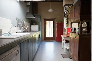 A narrow kitchen with a sink, stove, and cabinets. - Holiday Home in Small Hamlet Surrounded by Fields and Mountains (Bouvières)