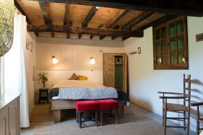 A traditional room with a wooden ceiling, a bed with a bench, a chair, and a small table with a vase. - Holiday Home in Small Hamlet Surrounded by Fields and Mountains (Bouvières)