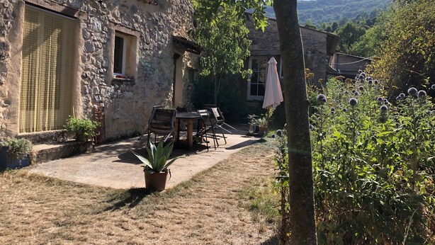 A stone building with a patio, outdoor furniture, and a potted plant. - Holiday Home in Small Hamlet Surrounded by Fields and Mountains (Bouvières)