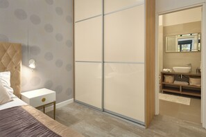 A bedroom with a bed, nightstand, and a sliding door leading to a bathroom. - Luxury villa Natali with pool, terrace and sea view (Podstrana - Sita)