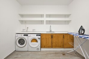 A laundry room with two washing machines, a sink, wooden cabinets, and a drying rack. - Luxury villa Natali with pool, terrace and sea view (Podstrana - Sita)