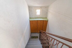 A narrow stairway with a wooden handrail and a small window at the top. - 'Wolf House' Apartment with Private Terrace, Wi-Fi, and Air Conditioning (Noto)
