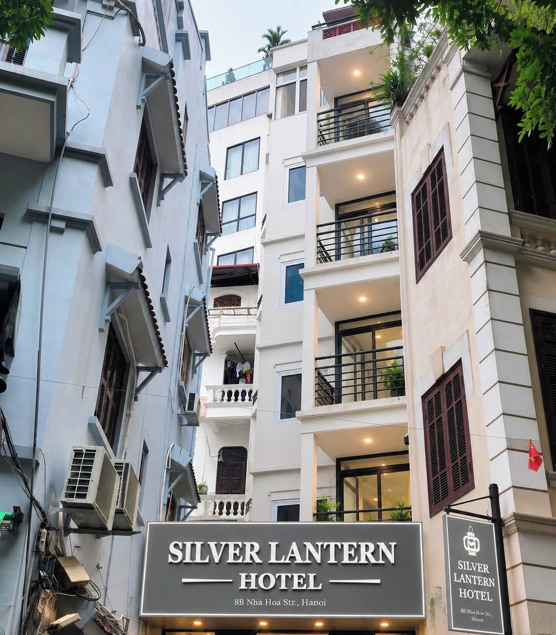 The exterior of the Silver Lantern Hotel with multiple balconies and air conditioning units.