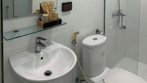 A modern bathroom with a glass shower enclosure, a white sink, and a toilet. - Silver Lantern Hanoi Hotel (Hanoi)