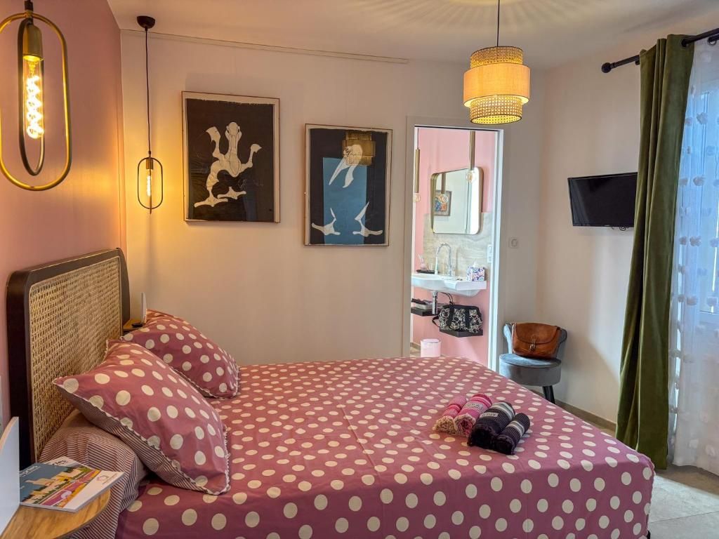 A bedroom with a bed, a bedside table, a lamp, and artwork on the wall.