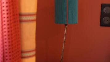 Eine Lampe auf einem runden Tisch vor roter Wand.