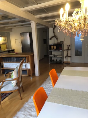 A dining area with a chandelier, wooden chairs, and a white tablecloth. - The historic town of Laupen near Bern—Top-Notch Apartment on the 1st Floor (Laupen)