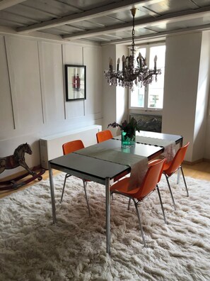 A dining area with a table, chairs, a chandelier, and a rocking horse. - The historic town of Laupen near Bern—Top-Notch Apartment on the 1st Floor (Laupen)
